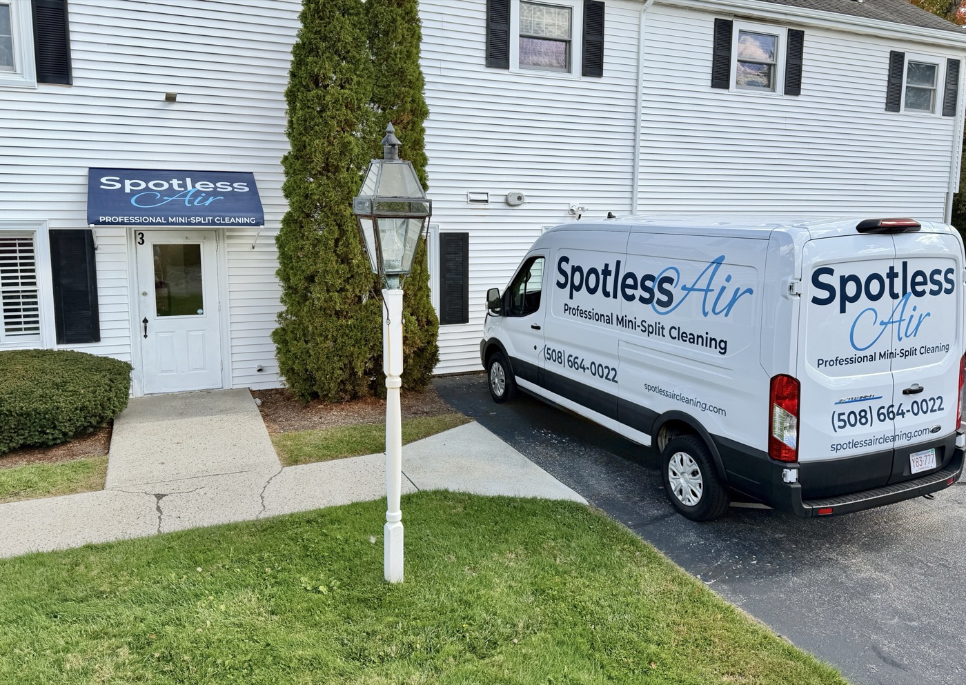 The Spotless Air office in MetroWest, with the branded canopy over the front door and a wrapped service van parked out front